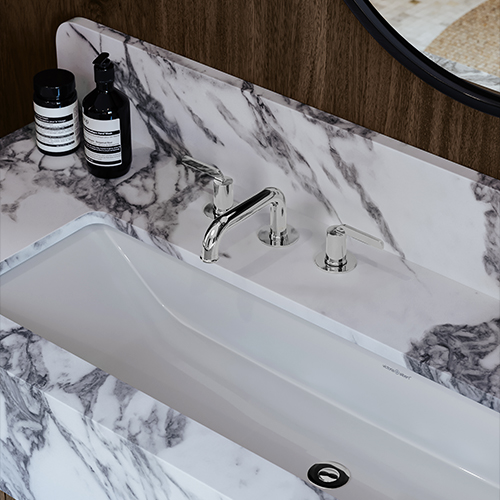 Chrome bathroom sink faucet with a marble sink.